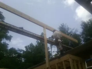 Carpenter setting a ridge beam over a new addition frame — Ice Dam Removal by Roofing Brothers in Monongahela