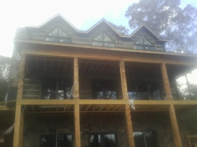 Dormers and porch framing on a large log home under construction — Roof Coating work by our crew in Monongahela
